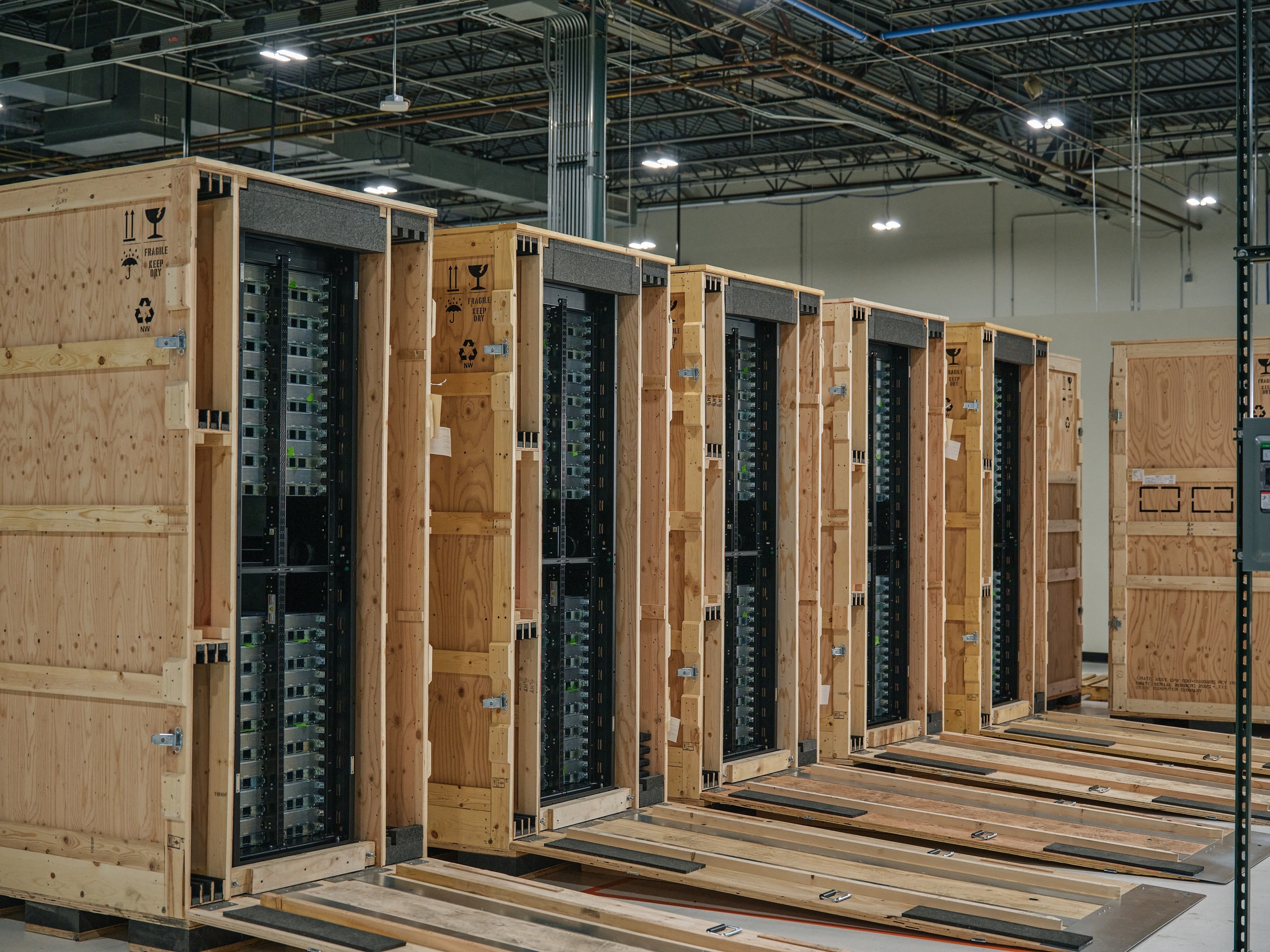 Six crated Oxide racks lined up on a storage floor